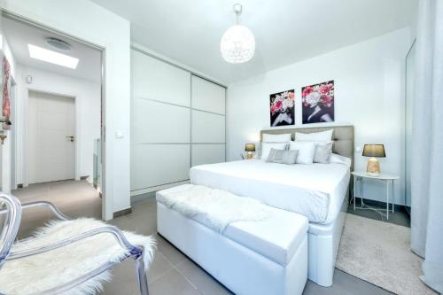 a white bedroom with a white bed and a chair at Casa Yus in Arrecife
