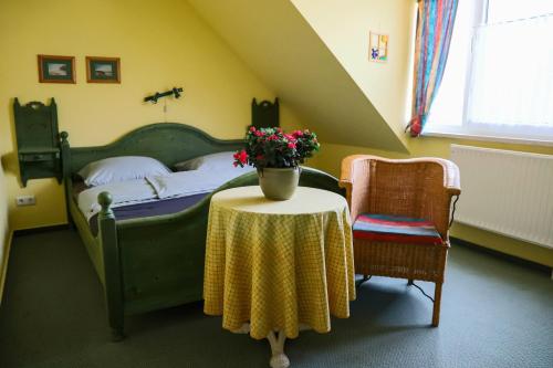 a bedroom with a bed and a table with flowers on it at Boddenkieker 15 in Zingst