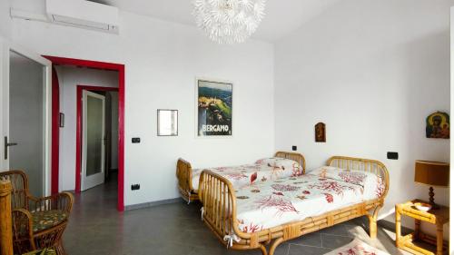 a bedroom with two beds and a chandelier at La Solatia in Zoagli