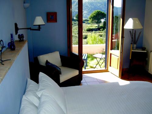 ein Schlafzimmer mit einem Bett, einem Stuhl und einem Fenster in der Unterkunft Sharíqua in Jérica