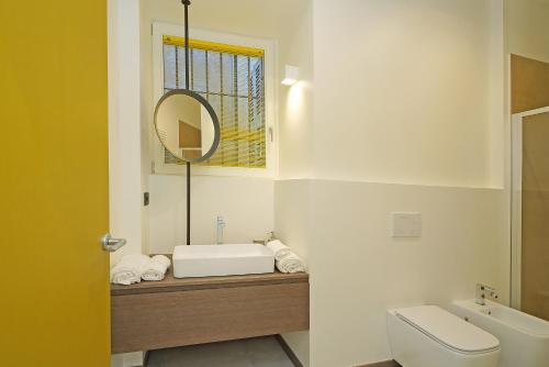 a bathroom with a sink and a toilet and a mirror at Gemhouse Ambra garda lake in Gargnano