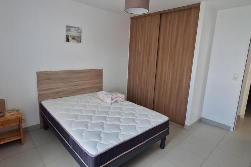 サント・マリー・ド・レにあるVilla Du Chaiのベッドと木製のキャビネットのある寝室