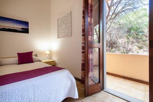 une chambre avec un lit et une porte coulissante en verre dans l'établissement Appartamento a 150 metri dal mare, à Valledoria