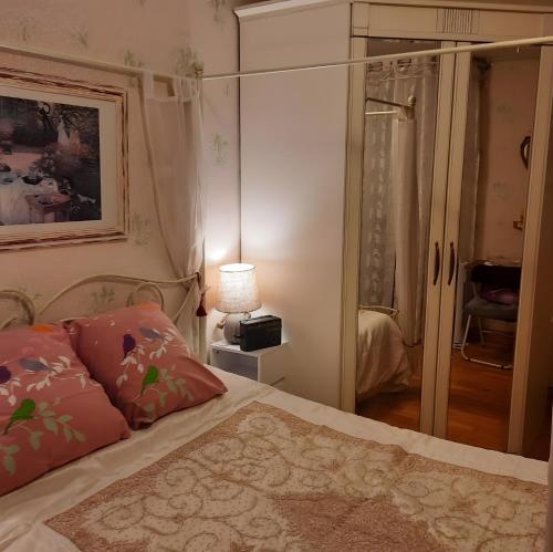 une chambre avec un lit et une armoire vitrée dans l'établissement Courseulles Comme À La Maison, à Courseulles-sur-Mer