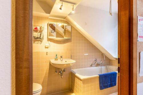 a bathroom with a sink and a tub and a toilet at Ferienwohnung Schlegel in Singen