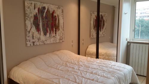 une chambre avec un lit et un miroir dans l'établissement Elegant Apart in City Centre of Cannes, à Cannes