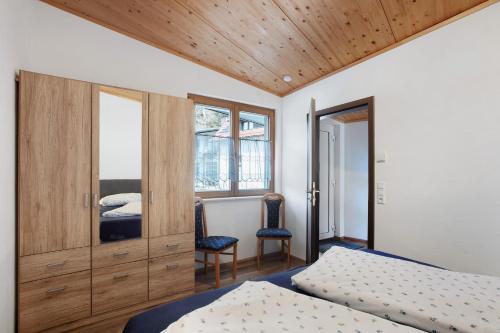 GeschwendFewo Rabenfelsen的一间卧室，配有两张床和木质天花板