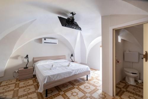 a white bedroom with a bed and a toilet at Gió home in Santa Maria al Bagno