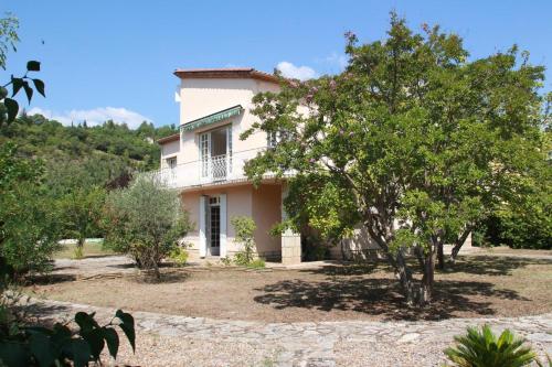 une maison blanche avec des arbres devant dans l'établissement Villa Loudéro, à Bédarieux