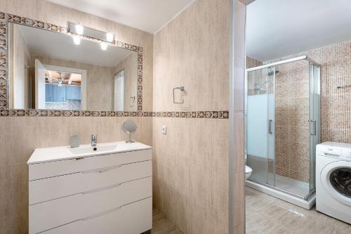 Un baño con lavabo y lavadora. en Torviscas Alta Vista, en Adeje