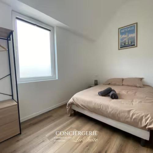 un dormitorio con una cama y una ventana en L'impasse, en Cherbourg-en-Cotentin