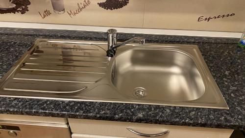 a stainless steel sink with a faucet in a kitchen at Appartment nahe Galopprennbahn in Iffezheim