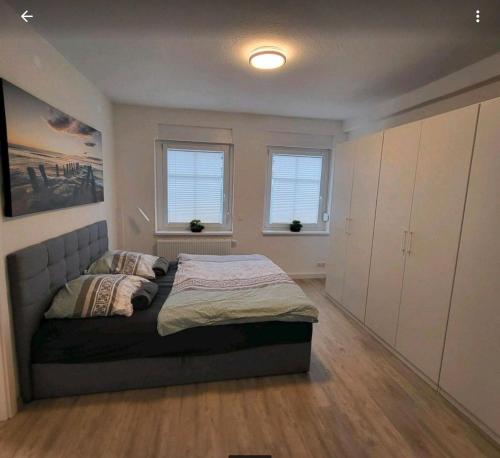 a bedroom with a bed and two windows at Ferienwohnung NR3 in Großräschen