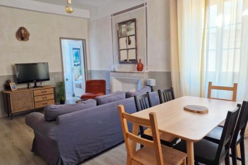 ein Wohnzimmer mit einem blauen Sofa und einem Tisch in der Unterkunft Casa Delia in LʼÎle-Rousse