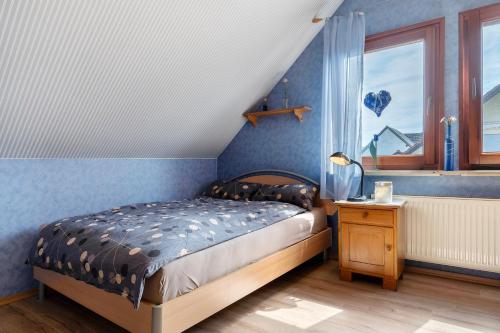 a bedroom with a bed and a blue wall at Ferienhaus am Rhein in Rheinau