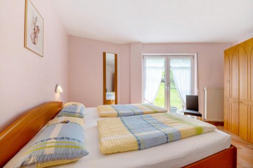 two beds in a bedroom with a window at Gästehaus Mühlenhof - Spätburgunder in Maring-Noviand