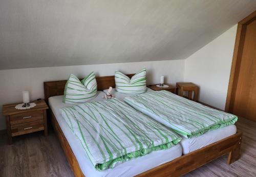a bedroom with a bed with green and white pillows at Gästehaus Nietmann_ Ferienwohnung 6 in Altenau