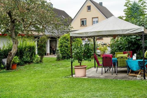 a table and chairs under a tent in a yard at Ferienwohnung Walter in Ringsheim