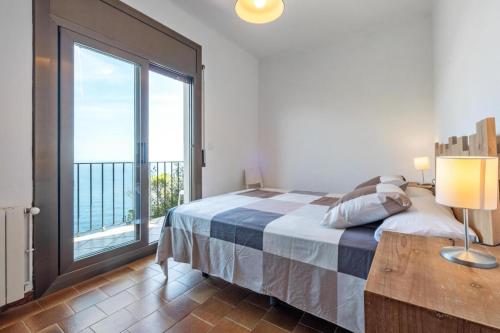 a bedroom with a bed and a large window at Casa Con Vistas Aiguablava in Tamariu