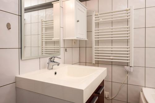 a white bathroom with a sink and a mirror at Bel Appartement Au Pied Des Pistes in Saint-François-Longchamp