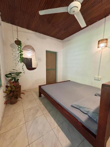 a bedroom with a bed and a ceiling fan at Backpackers in Matara