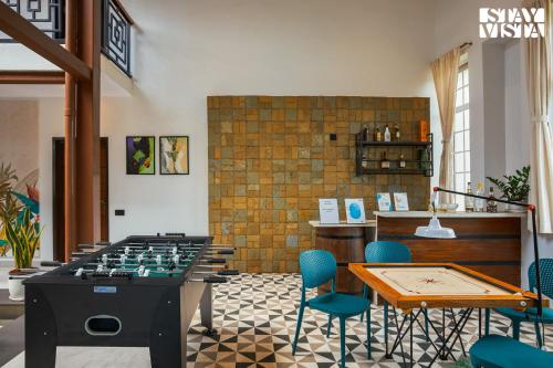 a room with a foosball table and blue chairs at StayVista's Rustique Radiance - Hillside Retreat with Outdoor Pool & South Indian Architecture in Khopoli