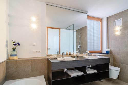 une salle de bain avec deux lavabos et un grand miroir dans l'établissement Architektenhaus c1 mit Seesicht, à Öhningen