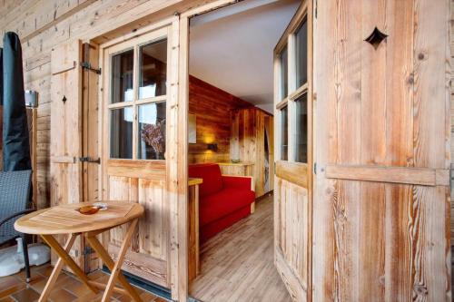 a room with a red couch and a wooden wall at Gästehaus Panorama - Appartement 2 in Reit im Winkl