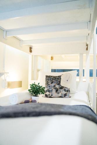 a bedroom with a bed with a plant on it at Qilombo Hostel Silom in Bangkok
