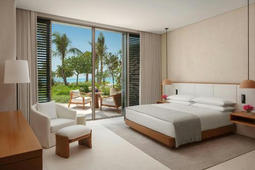 a bedroom with a bed and a table and chairs at The Red Sea EDITION in Ḩanak