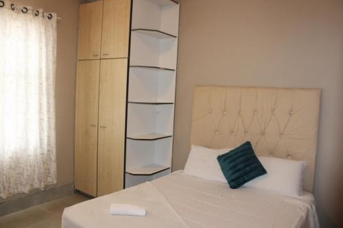 a bedroom with a bed and a book shelf at Chic Guest House Alberton in Alberton