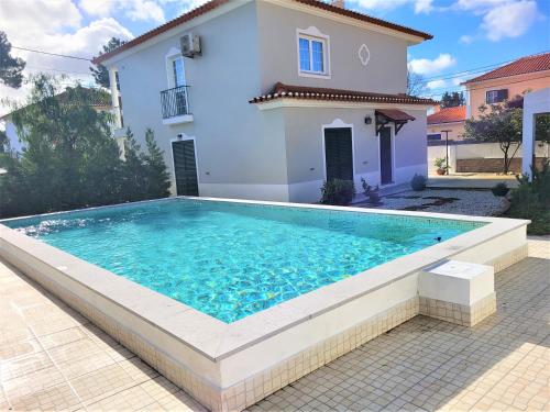 a villa with a swimming pool in front of a house at Casa Luz - Brejos de Azeitão in Azeitao