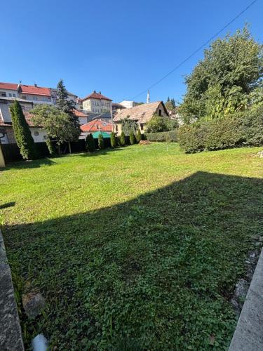 a large yard with green grass and buildings at Sunny Garden Old Town in Sarajevo