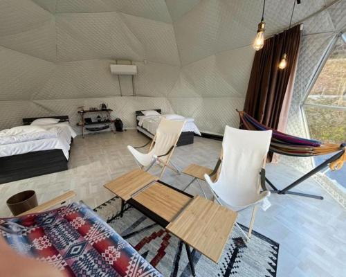 a room with a tent with two beds and a hammock at Glamping x Kominka MASAZUMI Tei -and- GLAMPING&BBQ VILLAGE Takibi Terrace - Vacation STAY 97095v in Kawabe