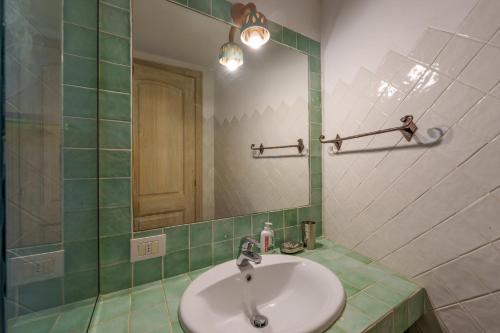 une salle de bain avec un lavabo et un miroir dans l'établissement Villetta Bomboniera, à Arzachena