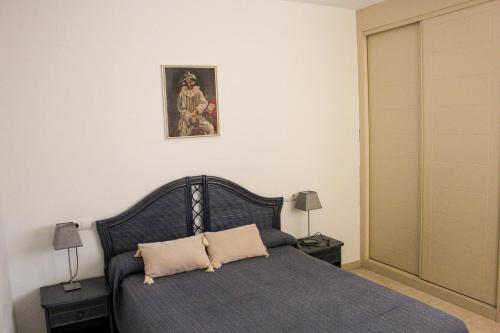 Un dormitorio con una cama y un cuadro en la pared. en Apartamentos Amatista Unitursa, en Calpe
