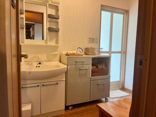 農家民宿ととのや في كانازاوا: حمام أبيض مع حوض ومرآة