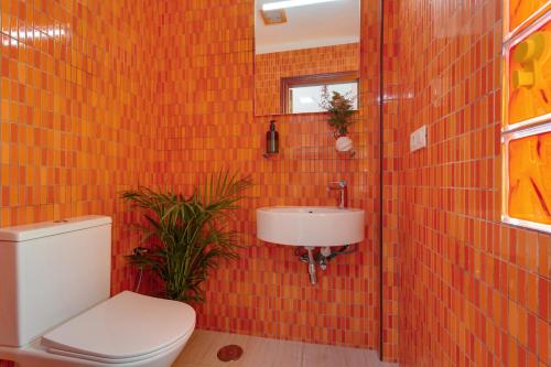 an orange tiled bathroom with a toilet and a sink at Luxury Ático Plaza in Playa de San Juan
