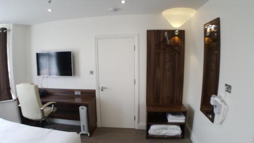 a bedroom with a desk and a bed with a computer at Heathrow-Windsor Guest House in Slough