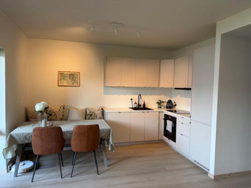 a kitchen with a table and chairs in a room at New modern apartment in Sandefjord