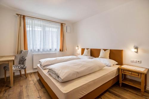 a bedroom with a large bed and a window at Ciasa Silvia in San Martino in Badia