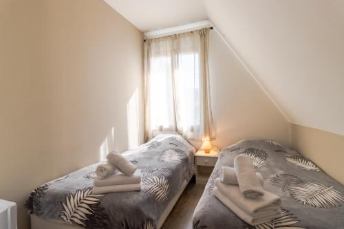ein kleines Schlafzimmer mit zwei Betten und einem Fenster in der Unterkunft Maison Fleurie in Castelnaud-la-Chapelle