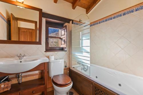 a bathroom with a toilet and a sink and a tub at Valle de Bueida El Grillo in Rodiles