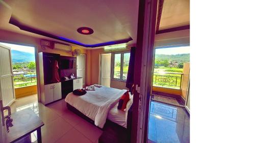 une chambre avec un lit dans une pièce avec des fenêtres dans l'établissement HOTEL ROYAL Inn, à Trisūli Bāzār