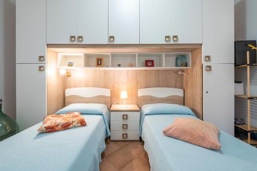 2 Betten in einem Zimmer mit blauer Bettwäsche in der Unterkunft Casa vacanza Mar Mediterraneo in Flumini di Quartu