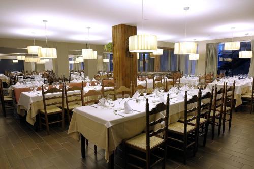 a dining room with tables and chairs and chandeliers at Hotel Kandahar in Pas de la Casa
