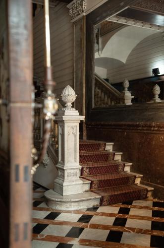 a staircase with a stone column on a checkered floor at Catalonia Plaza Catalunya in Barcelona