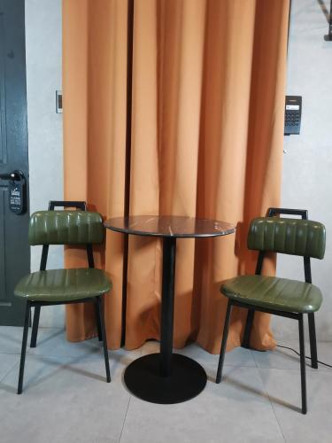 two chairs and a table and a table and two chairs at Townhouse Oak Grey Hotel Near Clark International Airport in Pampang