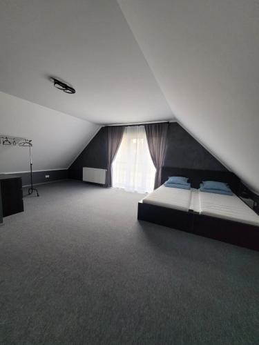 ein großes Zimmer mit einem Bett und einem Fenster in der Unterkunft Miķeļi in Īslīce