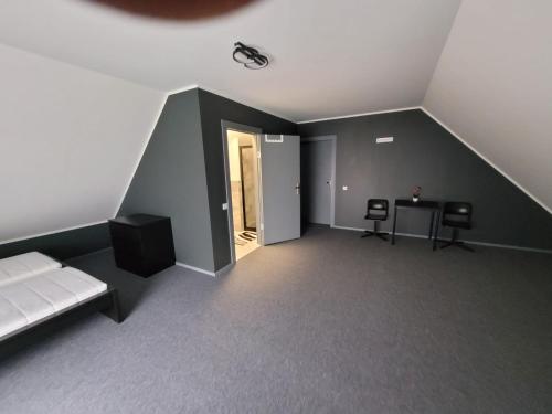 Pokój na poddaszu z łóżkiem, stołem i krzesłami w obiekcie Miķeļi 